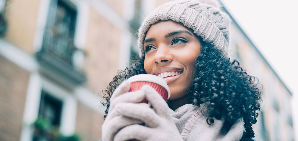 Image of Curly Hair woman in the city holding coffee