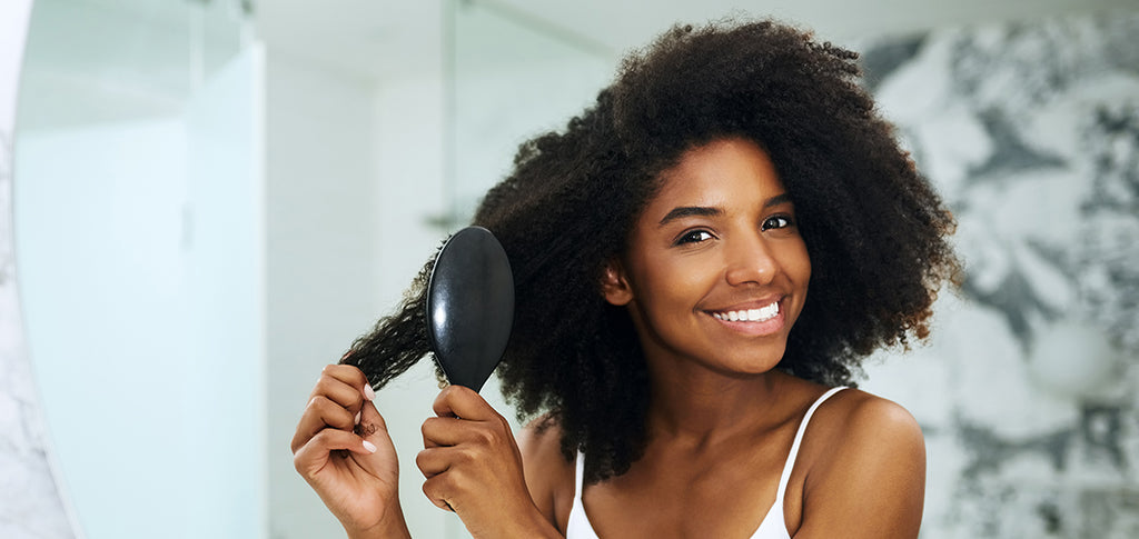 Image of Young woman brushing her hair